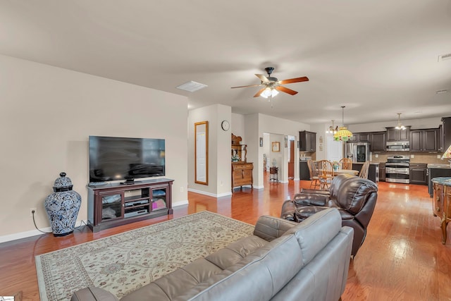 living room with light wood-type flooring and ceiling fan