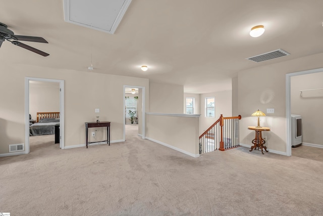 interior space featuring light carpet and ceiling fan