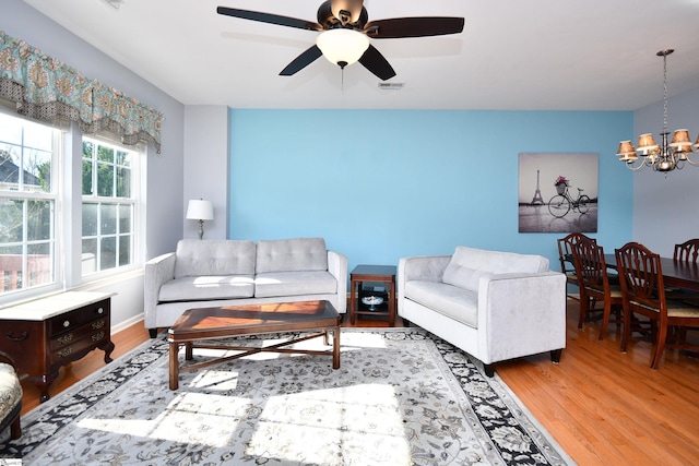 living room featuring light hardwood / wood-style flooring and ceiling fan with notable chandelier