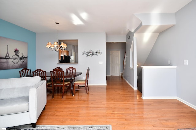 dining space featuring light hardwood / wood-style floors and a notable chandelier