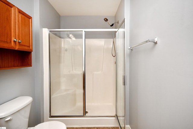 bathroom featuring an enclosed shower and toilet