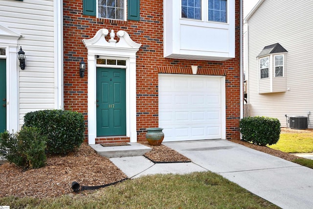 view of exterior entry featuring cooling unit and a garage