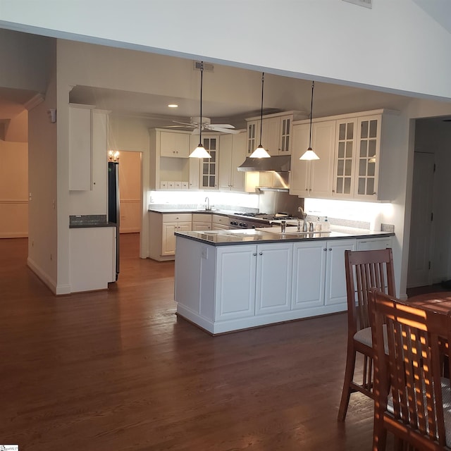 kitchen featuring kitchen peninsula, sink, decorative light fixtures, white cabinets, and dark hardwood / wood-style floors