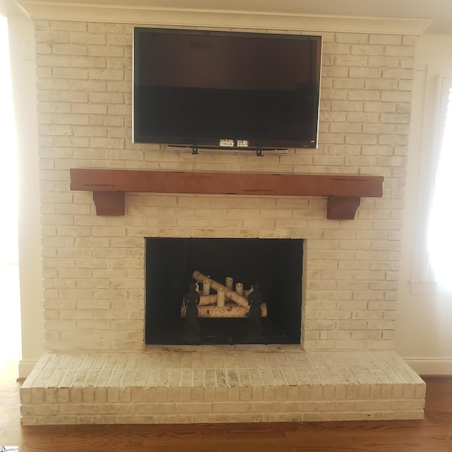 interior details with a brick fireplace and hardwood / wood-style flooring