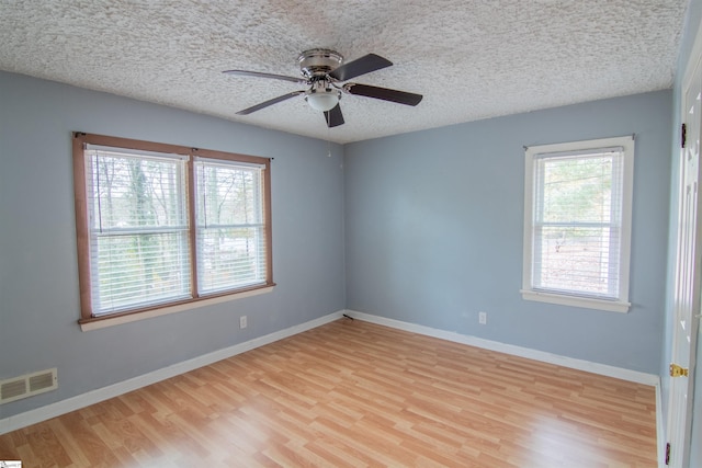 spare room featuring ceiling fan, a textured ceiling, and light wood-type flooring