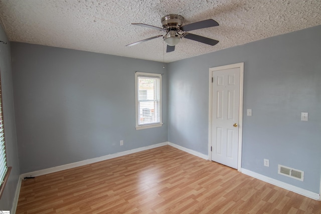 unfurnished room featuring ceiling fan, light hardwood / wood-style floors, and a textured ceiling