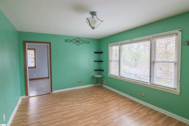 spare room with light wood-type flooring and a wealth of natural light