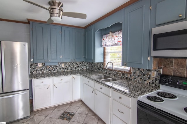 kitchen featuring blue cabinetry, stainless steel appliances, white cabinetry, and sink