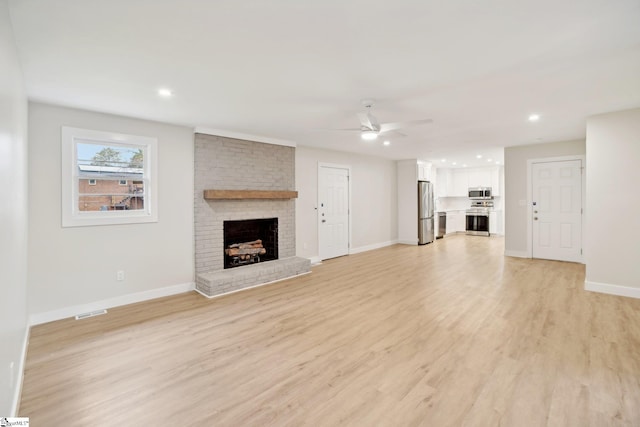 unfurnished living room with a fireplace, light hardwood / wood-style flooring, and ceiling fan