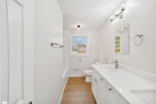 bathroom with hardwood / wood-style floors, vanity, and toilet