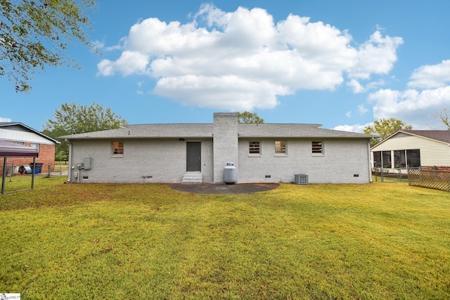 back of property with central air condition unit and a yard