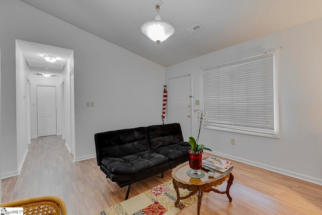 living room featuring vaulted ceiling and light wood-type flooring