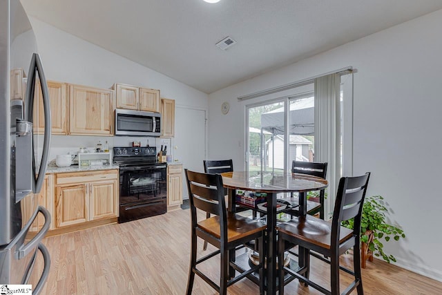 kitchen featuring appliances with stainless steel finishes, light hardwood / wood-style flooring, vaulted ceiling, and light brown cabinetry