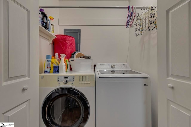 laundry room with electric panel and washer and clothes dryer