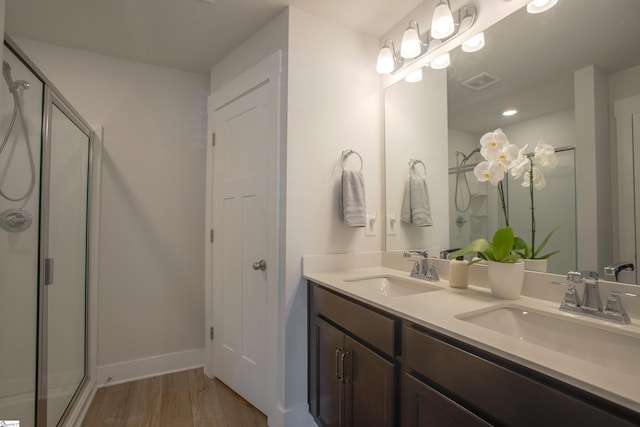 bathroom featuring hardwood / wood-style floors, vanity, and an enclosed shower