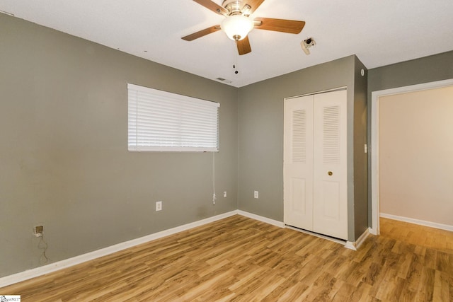 unfurnished bedroom with ceiling fan, wood-type flooring, and a closet