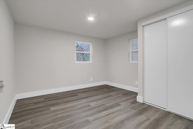 unfurnished bedroom featuring wood-type flooring and a closet