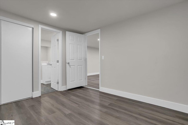 unfurnished bedroom featuring dark hardwood / wood-style flooring and ensuite bathroom