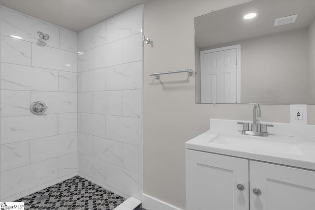 bathroom with vanity and tiled shower