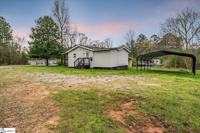 yard at dusk featuring a carport