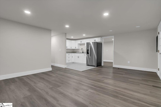 unfurnished living room featuring light hardwood / wood-style flooring and sink