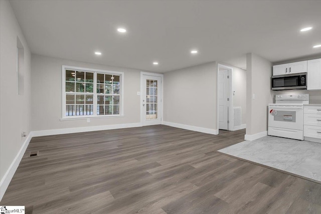 kitchen with white electric range, white cabinetry, and hardwood / wood-style floors