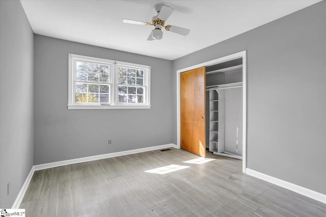 unfurnished bedroom with light wood-type flooring, a closet, and ceiling fan