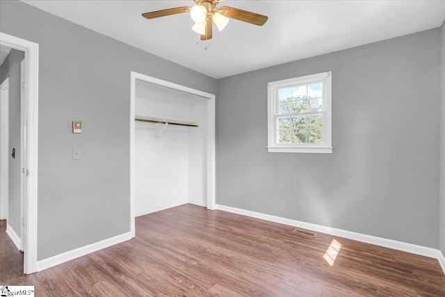 unfurnished bedroom with a closet, hardwood / wood-style flooring, and ceiling fan