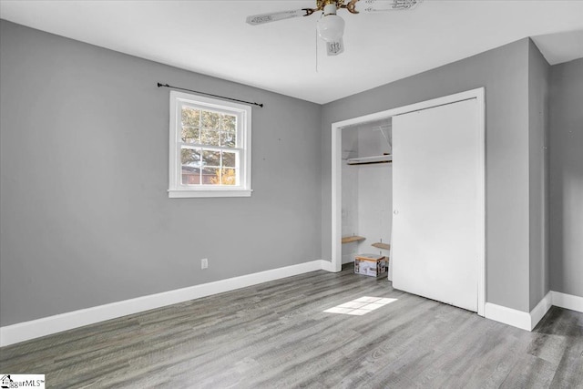 unfurnished bedroom featuring ceiling fan, a closet, and hardwood / wood-style flooring