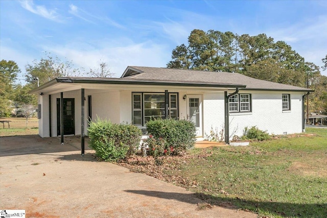 single story home featuring a front yard, a porch, and a carport