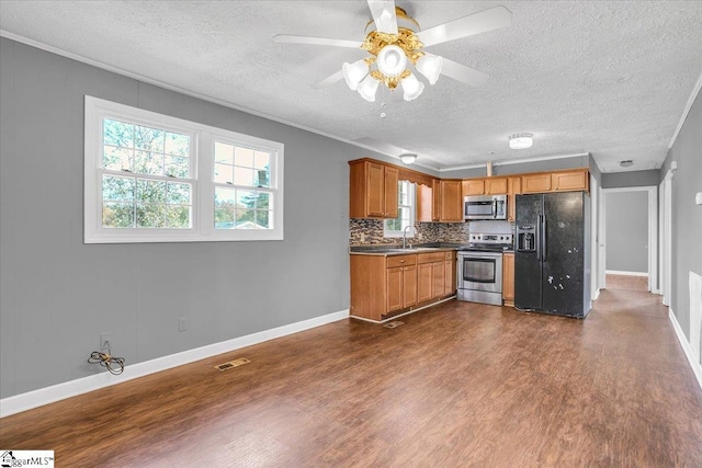 kitchen with decorative backsplash, stainless steel appliances, dark hardwood / wood-style floors, and crown molding