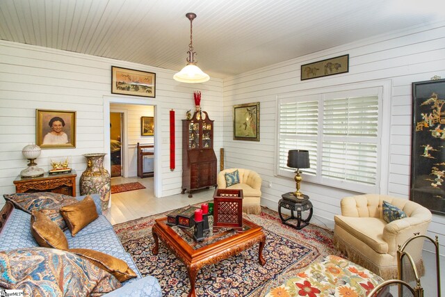 living room with light wood-type flooring and wooden walls