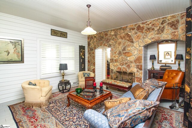 living room featuring wood walls, a fireplace, and wooden ceiling