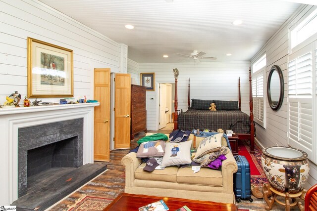 living room with ceiling fan, dark wood-type flooring, and wooden walls