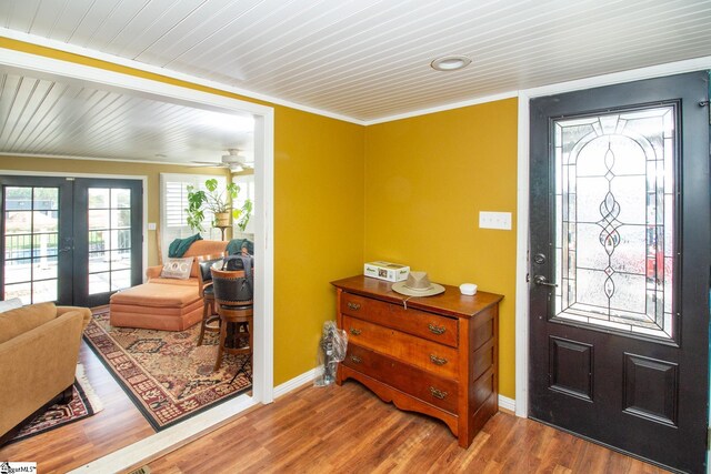 foyer featuring french doors, hardwood / wood-style flooring, ceiling fan, and ornamental molding