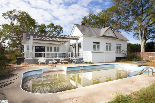 rear view of house featuring a pergola, a patio, and a fenced in pool