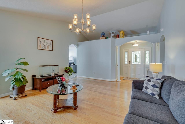 living room with an inviting chandelier, high vaulted ceiling, and light wood-type flooring