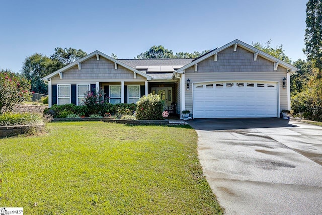 craftsman house with solar panels, a garage, and a front lawn