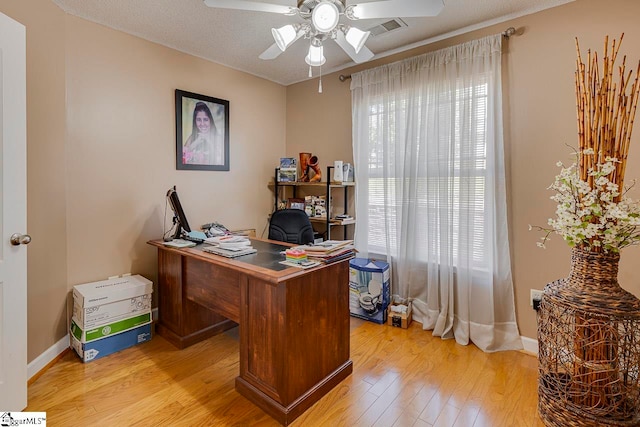 office area with ceiling fan, light wood-type flooring, and a textured ceiling