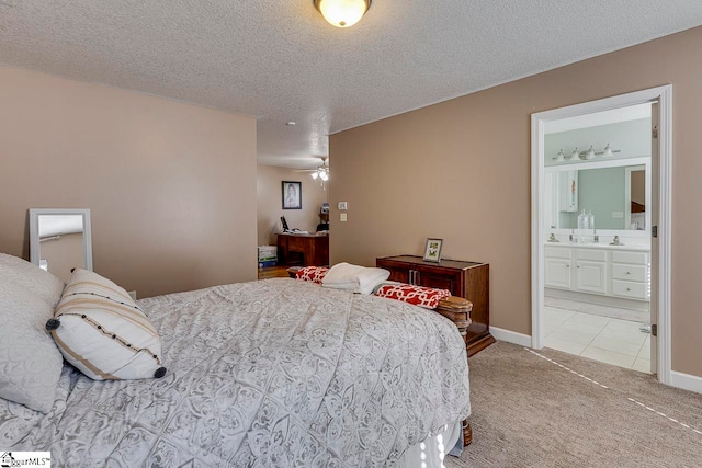 carpeted bedroom with connected bathroom, sink, and a textured ceiling