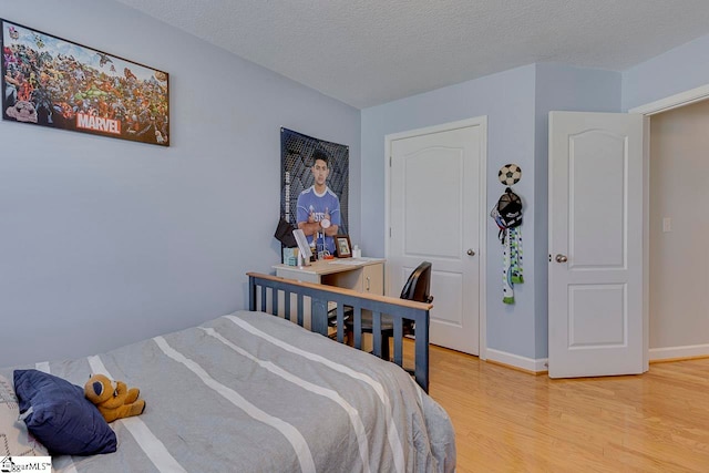 bedroom with hardwood / wood-style floors and a textured ceiling