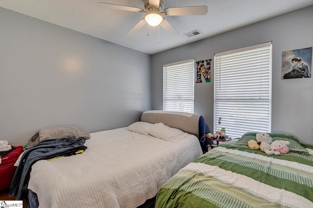 bedroom with ceiling fan and a textured ceiling