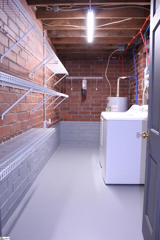 laundry room with separate washer and dryer, brick wall, and water heater