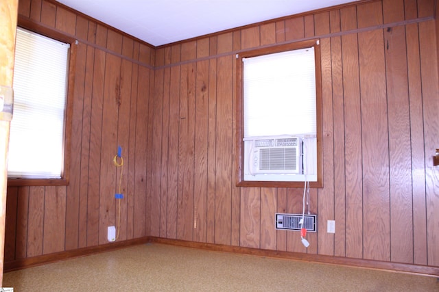 spare room with cooling unit, light colored carpet, and wooden walls