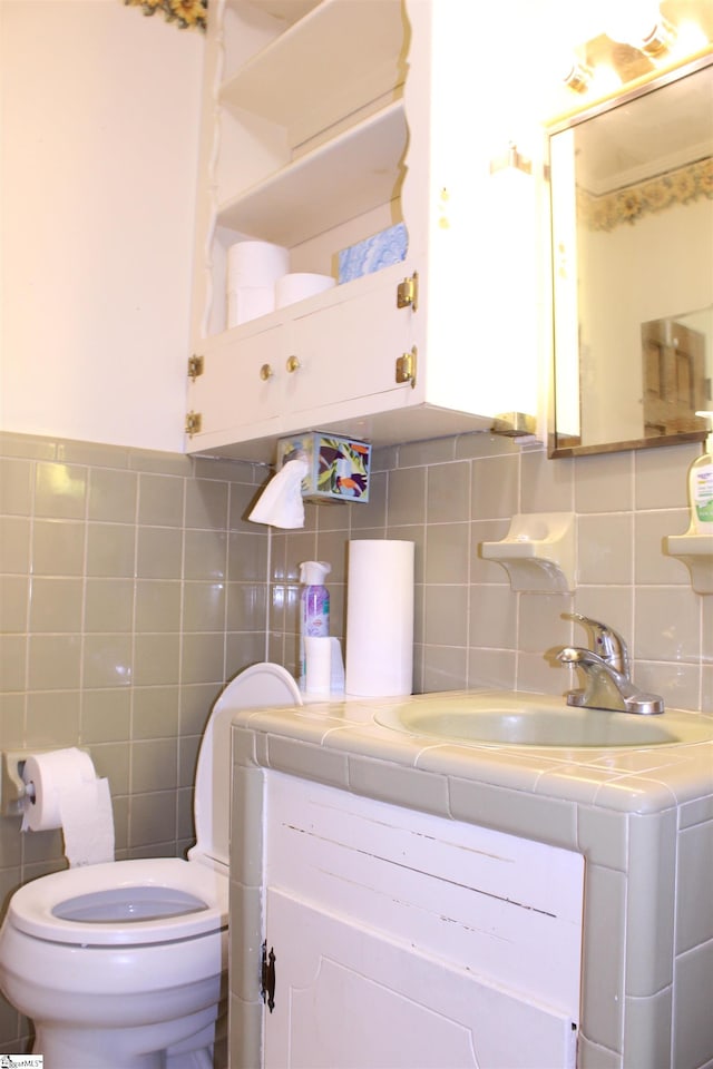 bathroom featuring vanity, toilet, tile walls, and tasteful backsplash