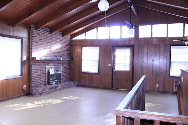 unfurnished living room featuring vaulted ceiling with beams and a healthy amount of sunlight