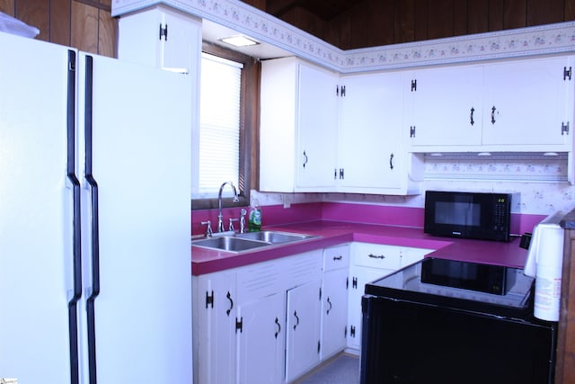 kitchen with white cabinetry, sink, and white refrigerator