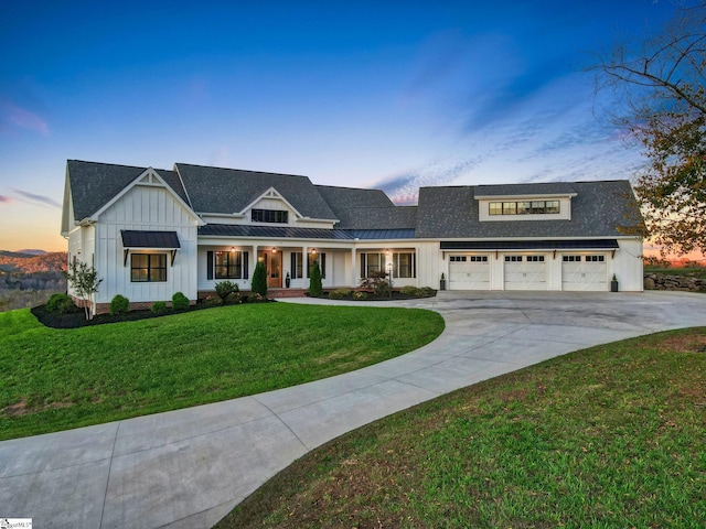 modern farmhouse style home featuring a yard and a garage