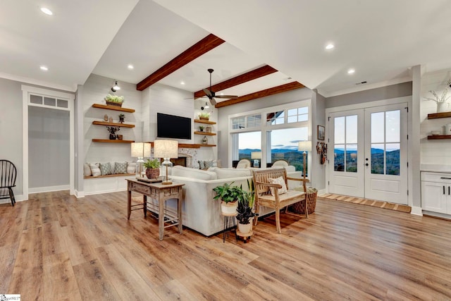 living room with french doors, ceiling fan, crown molding, light hardwood / wood-style flooring, and beamed ceiling