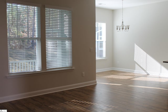 unfurnished room with dark hardwood / wood-style flooring and a chandelier